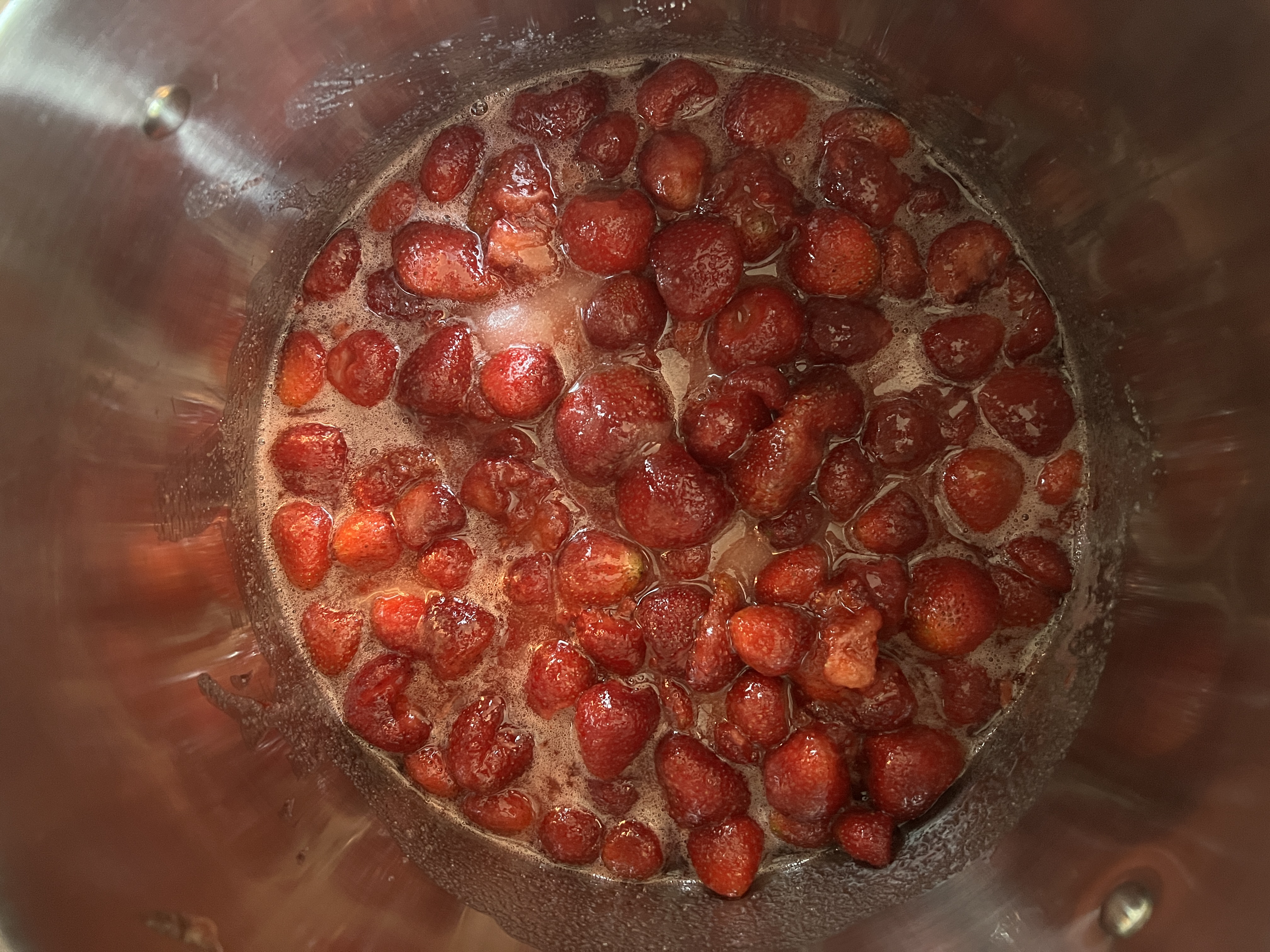 Strawberries simmering for preserves in a kitchen pot
